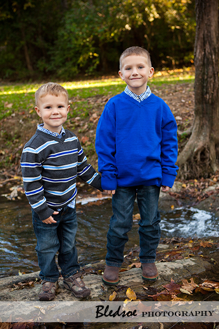 "Brothers standing in a creek."