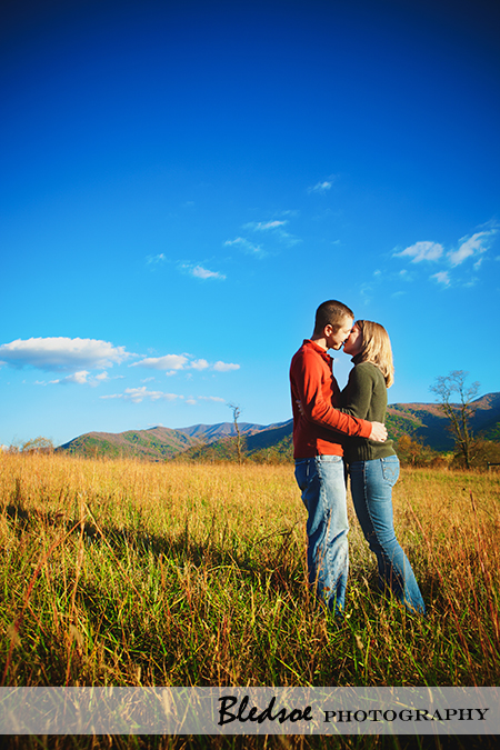 "Fall engagement photos under a blue sky in Cades Cove"