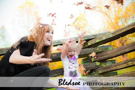 "Allie and mommy tossing fall leaves"
