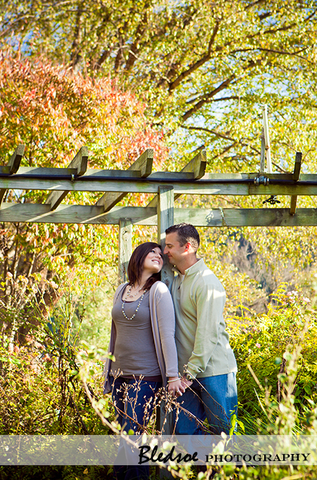 "Amy and Scott snuggle under the arbor at UT Gardens"