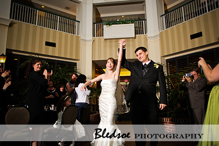 "Bride and groom entering the reception at Hilton Suites Brentwood"