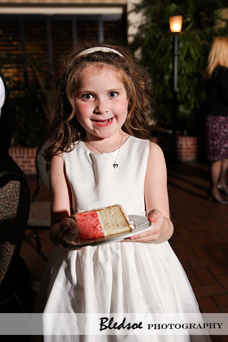 "Flower girl holding a piece of wedding cake"