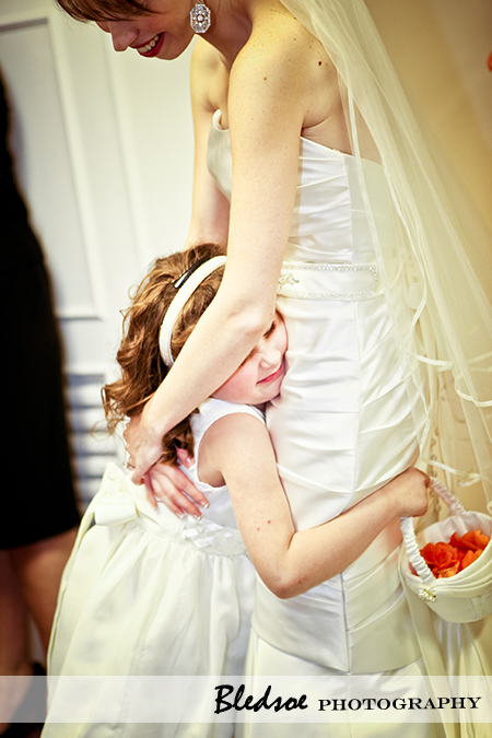 "Flower girl hugging bride"